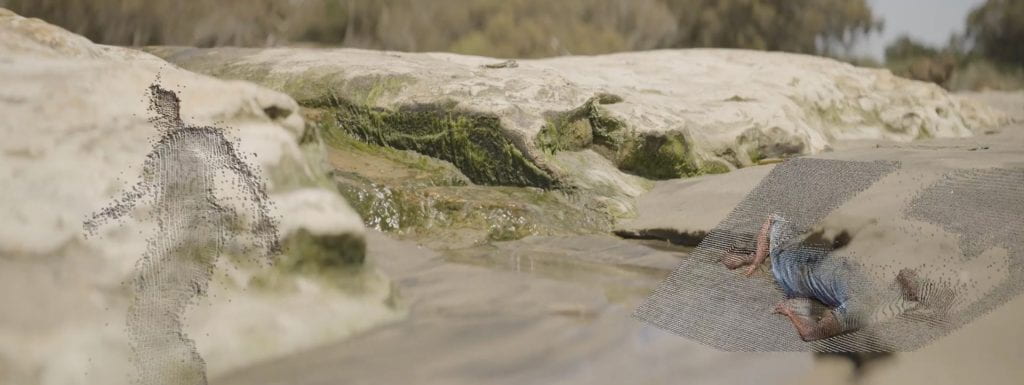 Mossy rock on the beach with water streaming through it, two 3D scans of dancers to the left and right of the water