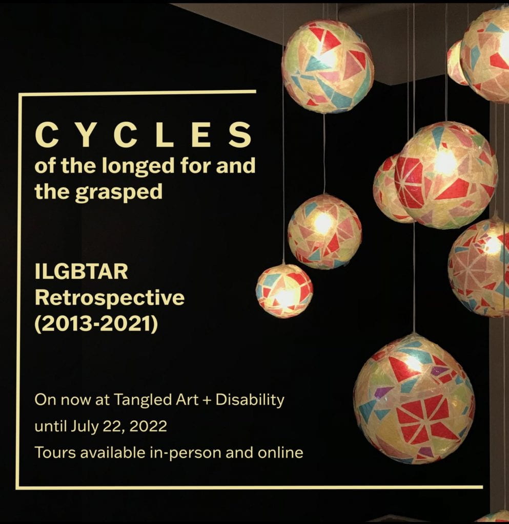 Cycles Exhibition at Tangled, colorful, lit up balls hang from the ceiling against a black background